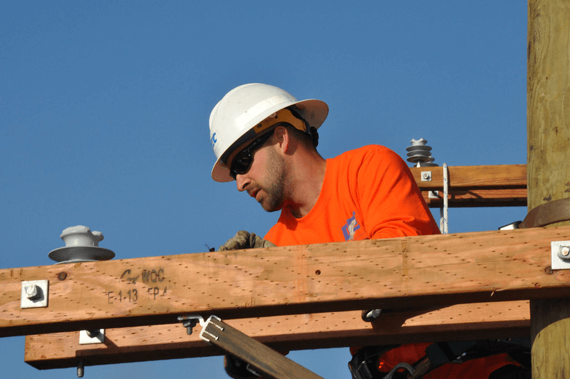 Crews work at the top of a pole