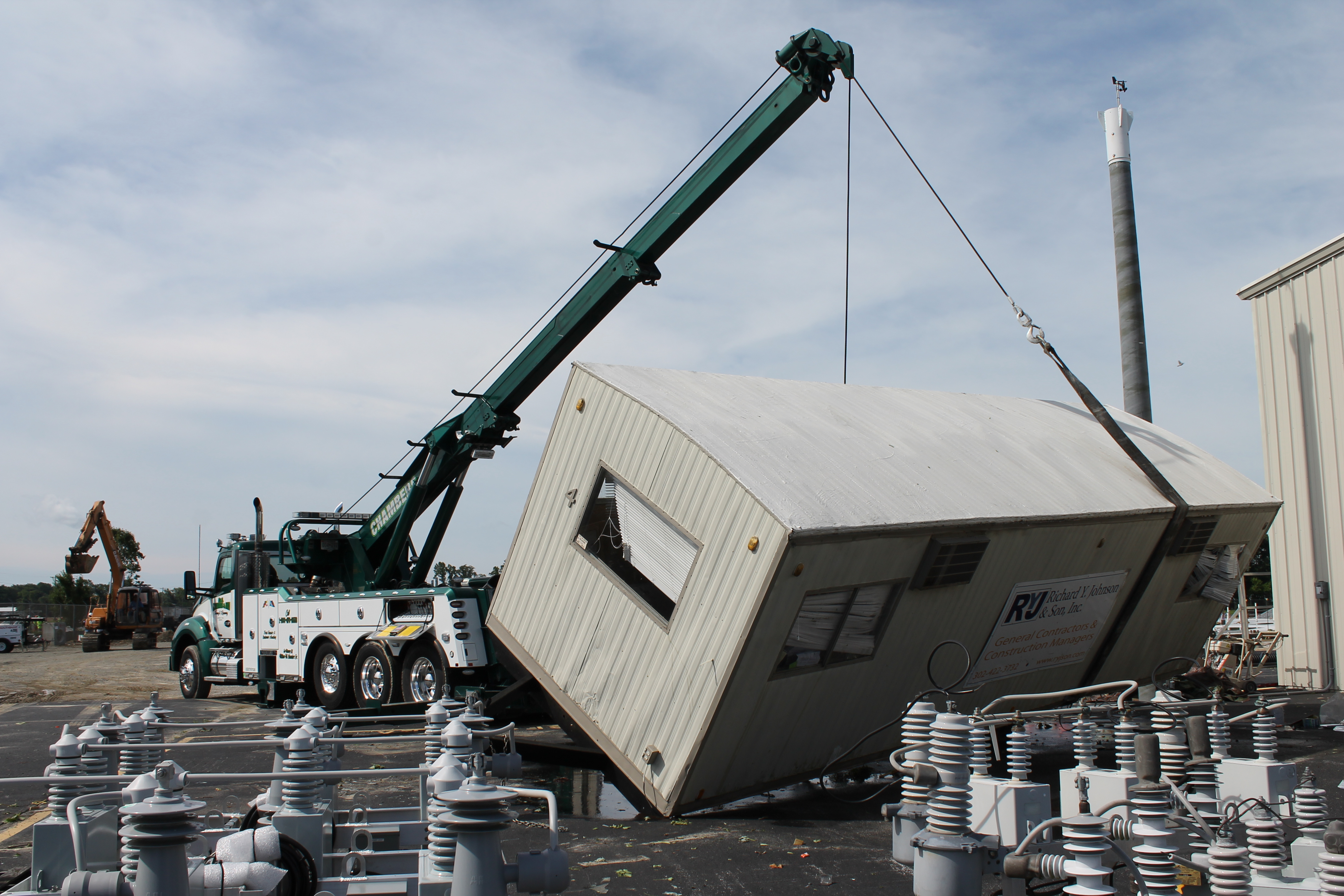 Crews lift trailers that were overturned in the storm.