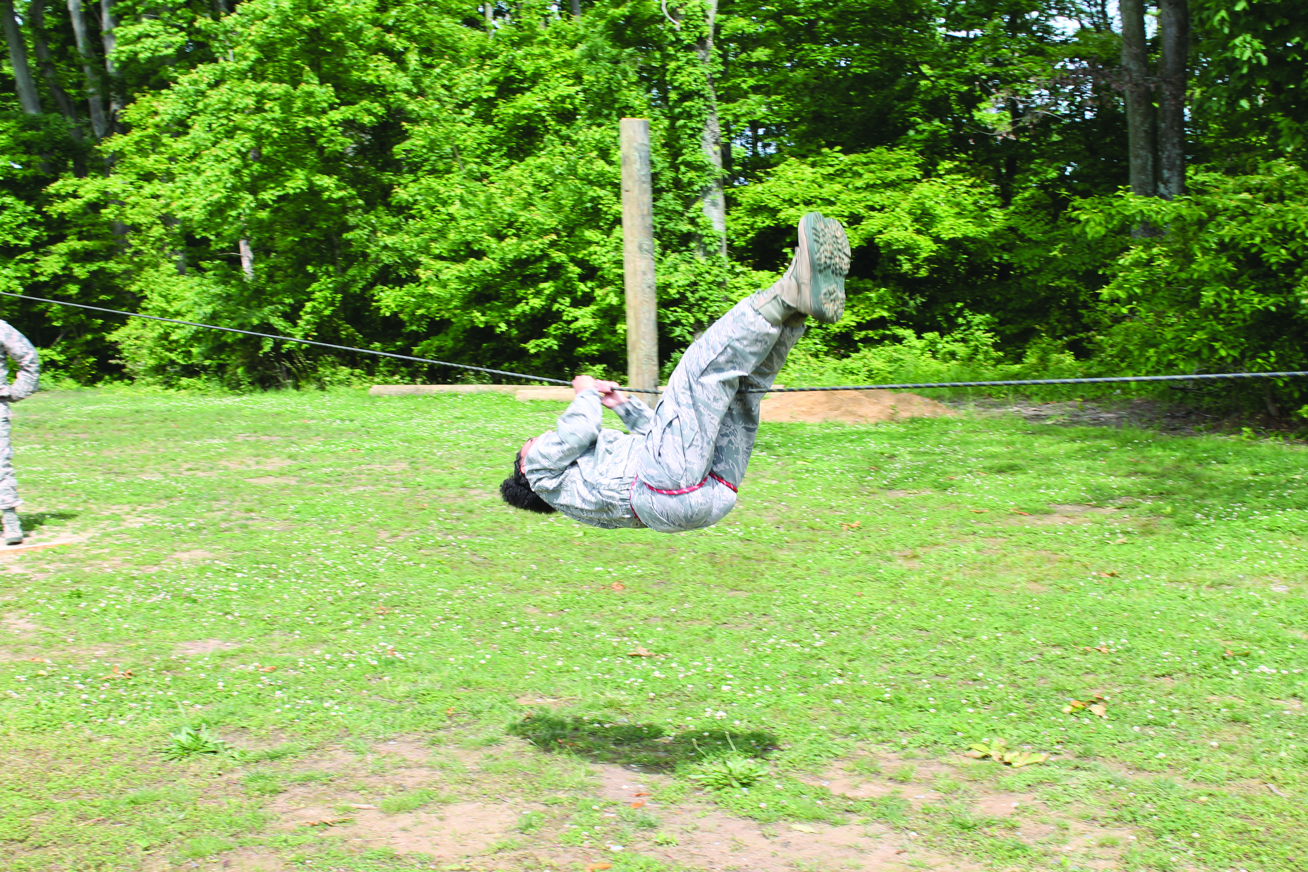 A student pulls herself across a rope line.