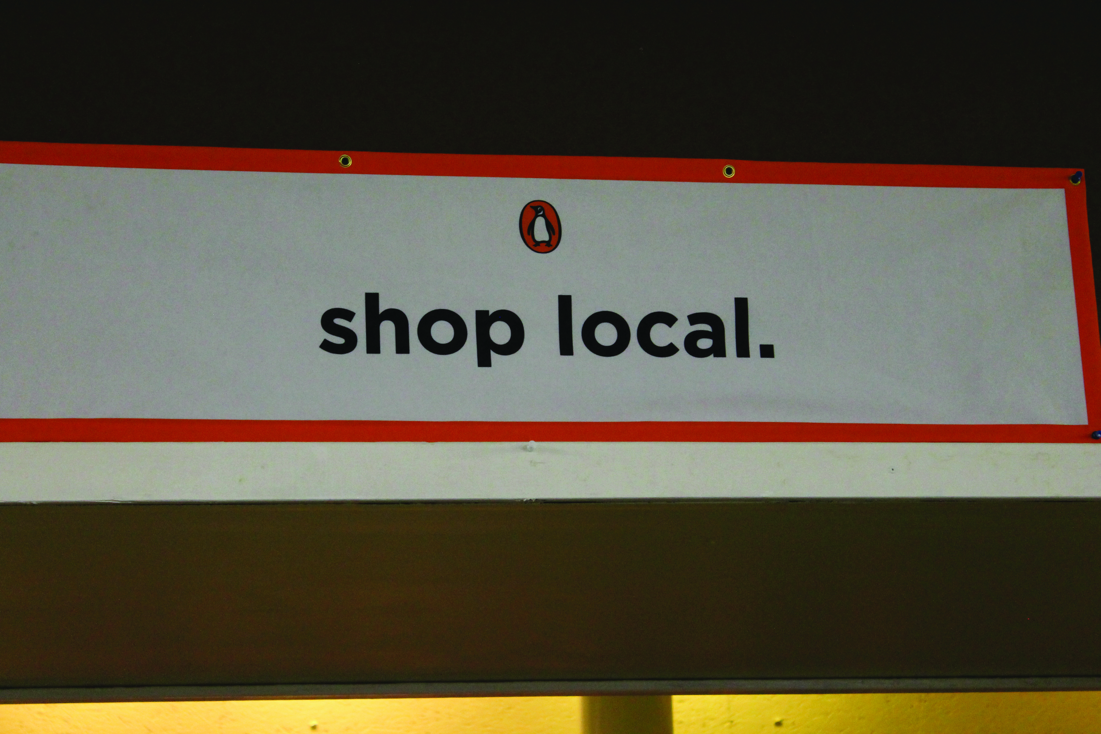 A reminder hangs in the bookstore, asking visitors to support local businesses.