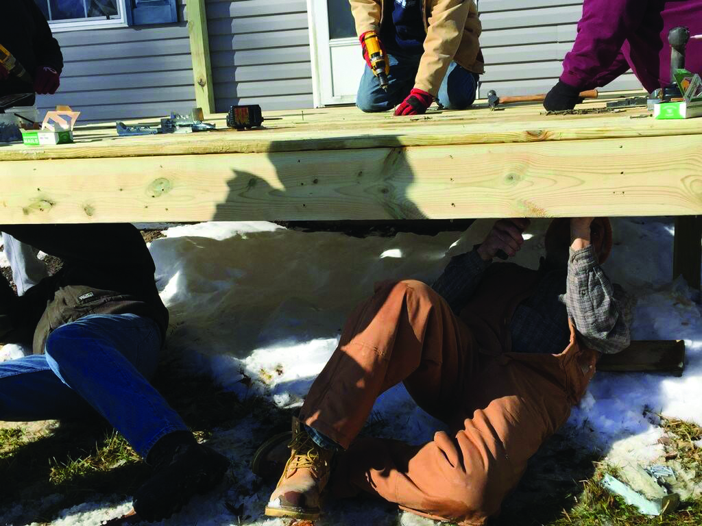 Volunteers work on a project for a member of the community.