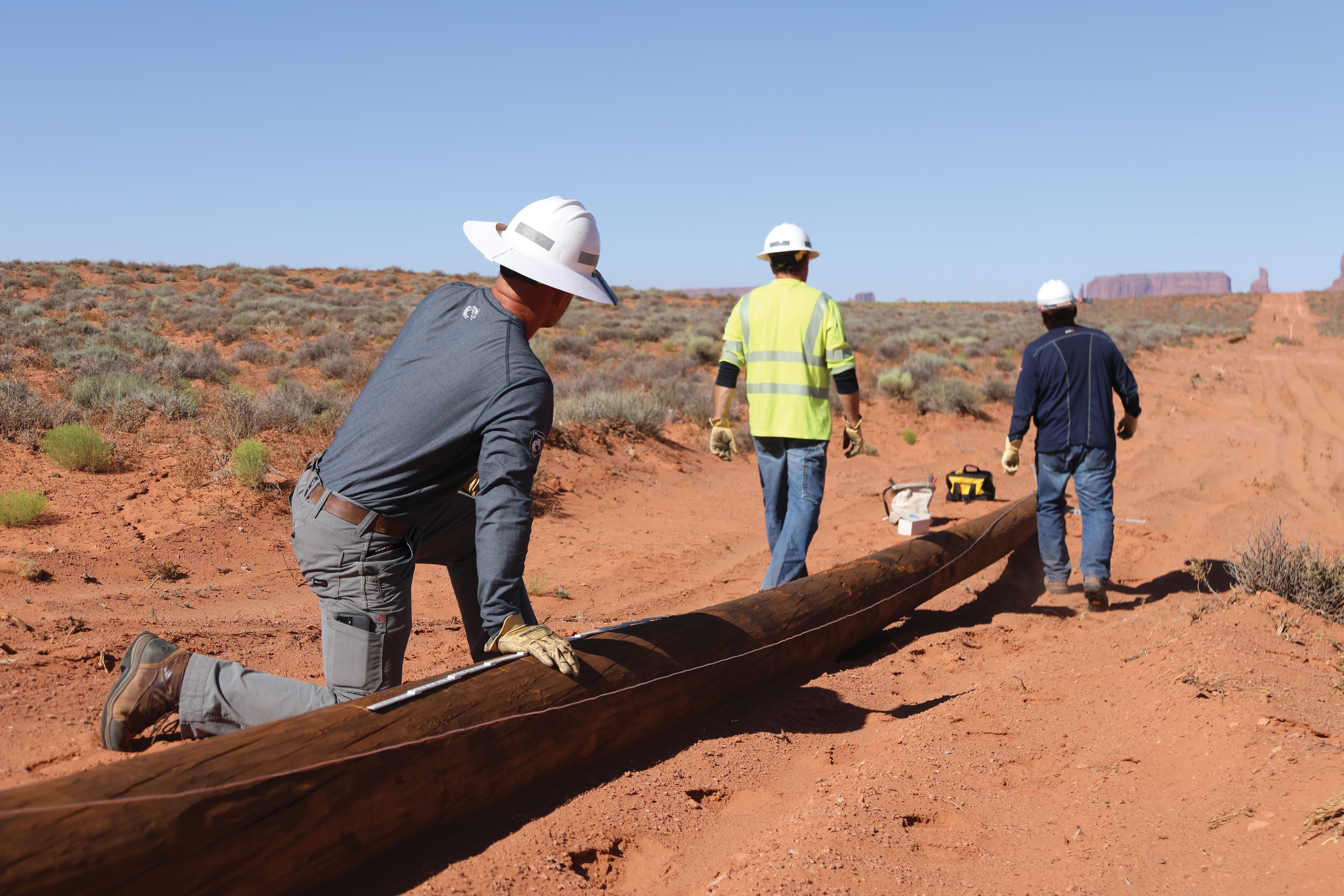 DEC lineworkers worked to frame and set utility poles to help bring power to those without in the Navajo Nation.