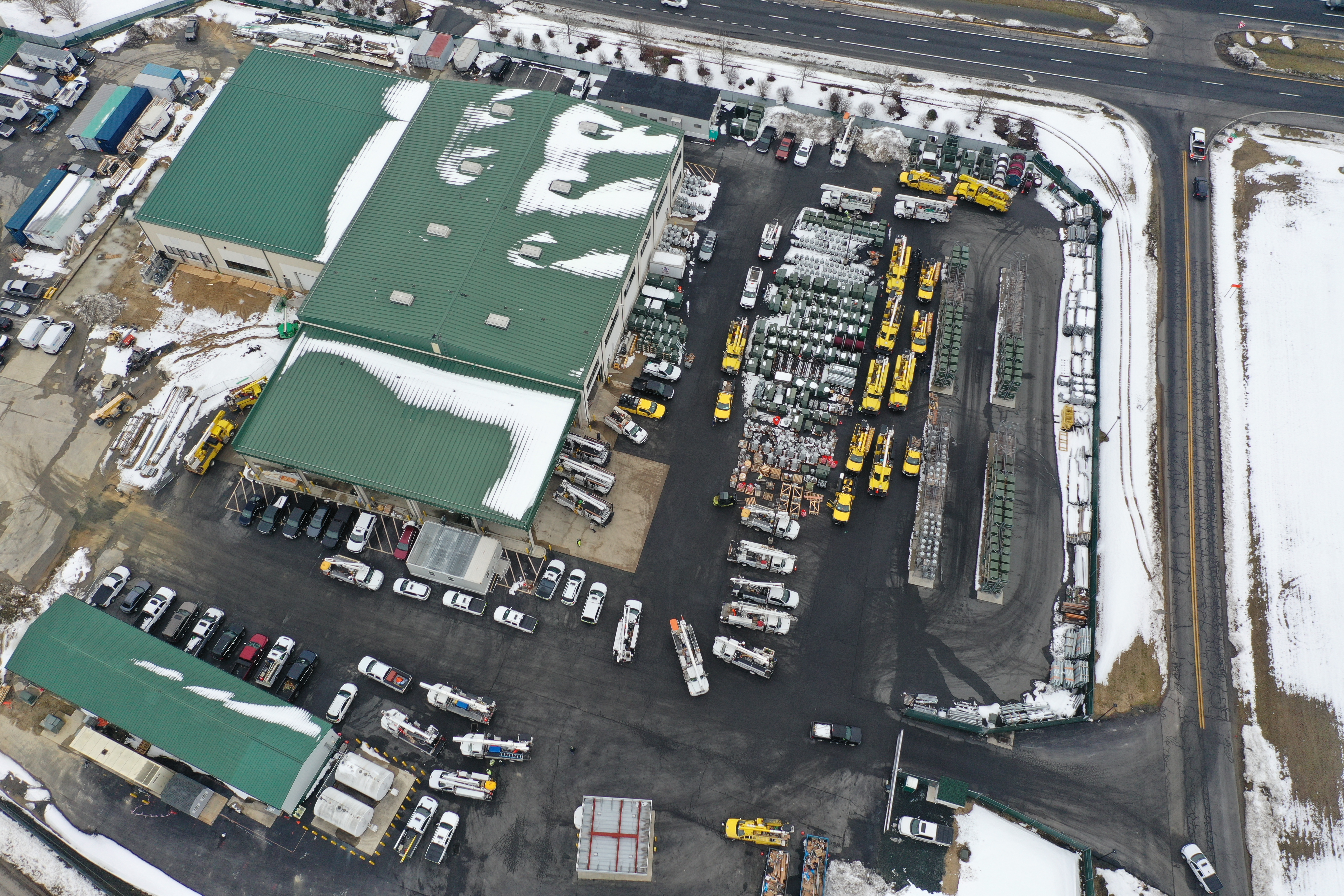 An aerial shot of work vehicles from Rappahannock Electric Cooperative, Mecklenburg Electric Cooperative and Northern Neck Electric Cooperative, along with DEC trucks, parked outside the Co-op's warehouse before a day of restoration efforts.
