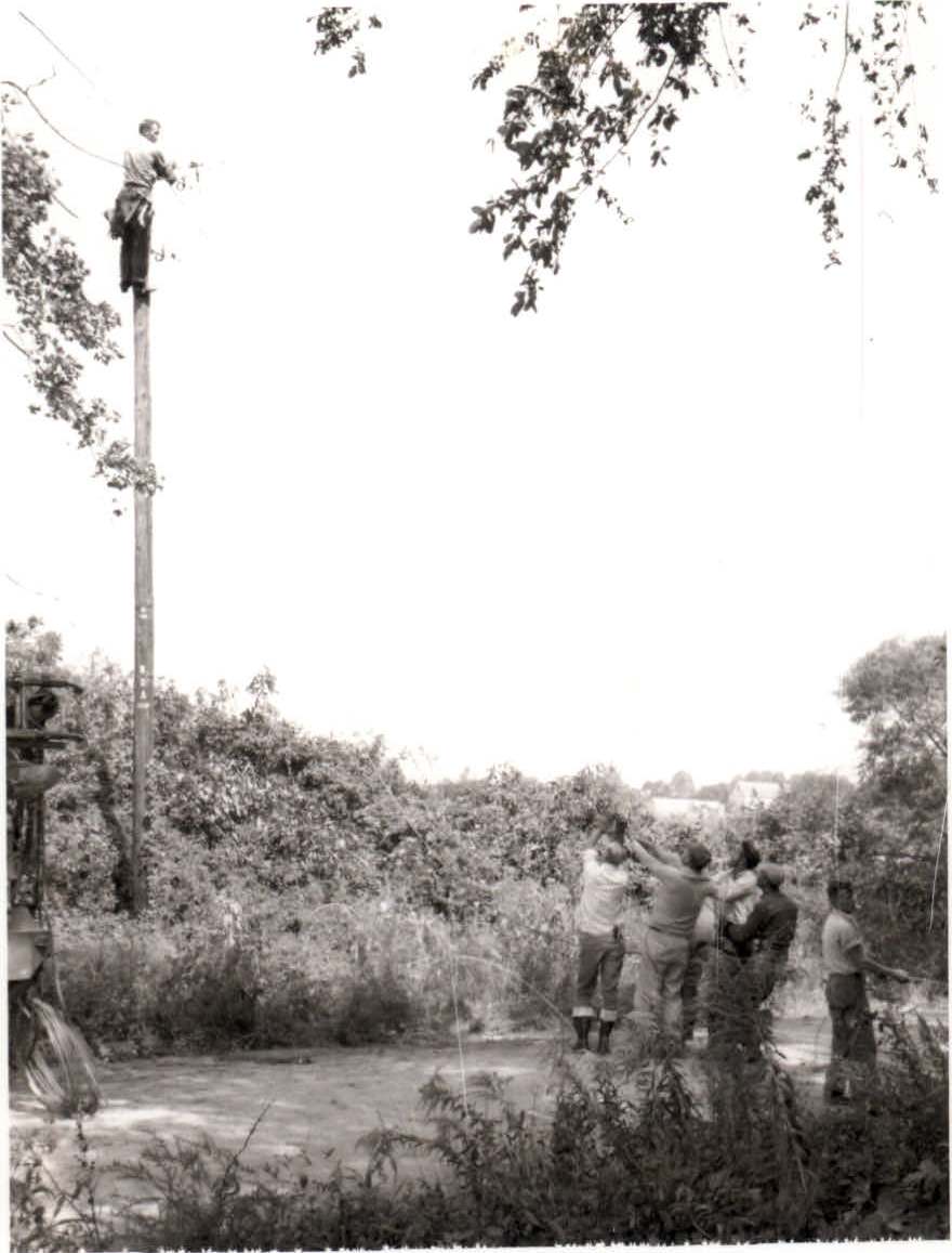 A crew works together to run power lines in the early days of DEC.