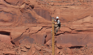 A DEC lineworker works atop a utility pole as part of the Light Up Navajo (LUN) initiative — a mutual aid program created to help bring power to more than 9,000 Navajo families.