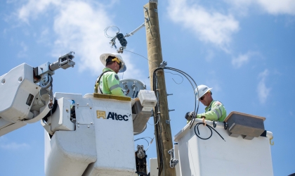 Crews work to restore power using a bucket truck to access lines.