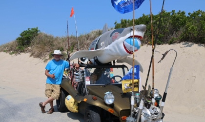 DEC member Art Wilson poses with his dune buggy, decked out with fishing rods, reels and a 110-pound fiberglass shark he has named Bruce on top.