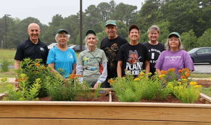 Co-op member Gary Liska (center) and Julie Callahan (right-of-center) pose with volunteers at the butterfly refueling station in Cape Henlopen State Park.