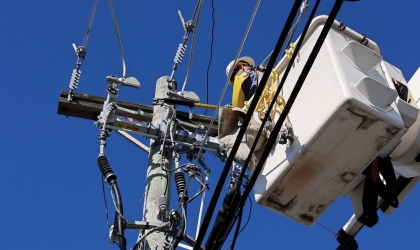 A DEC lineworker uses a bucket truck to access power lines.