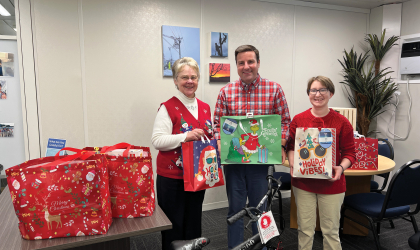 DEC employees stand in front of gifts brought in for this year's Children's Choice Angel Tree initiative.