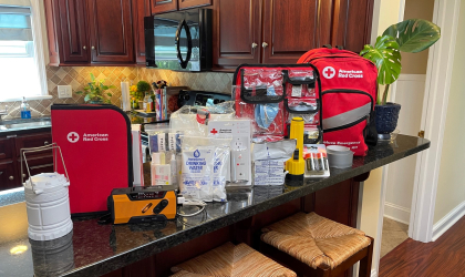 Photo displaying the items typically included in an emergency preparedness kit, such as a flashlight, radio, water and more.