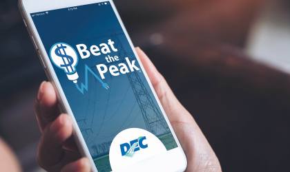 A member opens the Beat the Peak app on their phone. Using the app, members can receive notifications when DEC issues peak alerts, see how much money the program has saved members throughout the years and find tips on the best ways to save energy.