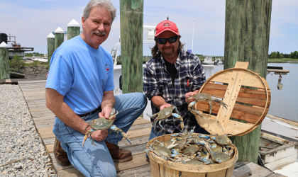 Todd Burrows (right) — owner of Sambo's Tavern in Leipsic — poses with his father Ike on the dock outside the family's restaurant.