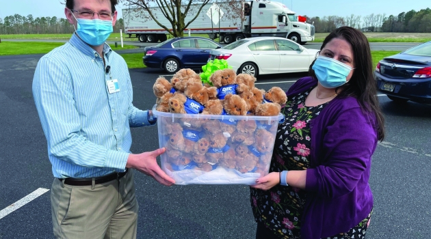 Two People Holdling Container of Bears