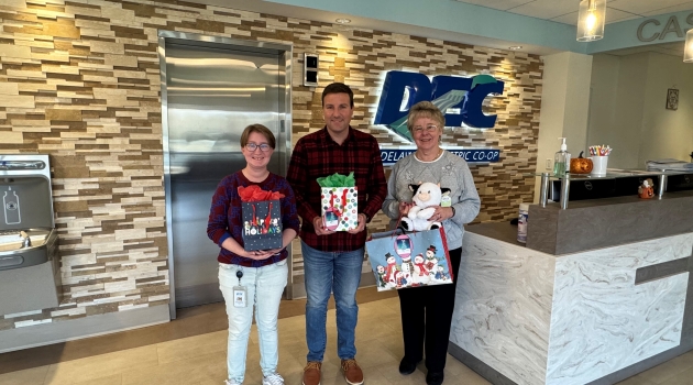 DEC employees stand with some of the gifts they and their coworkers donated in support of Children's Choice, and their mission to provide presents to children in need.