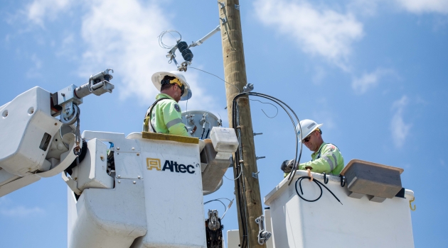 Crews work to restore power using a bucket truck to access lines.