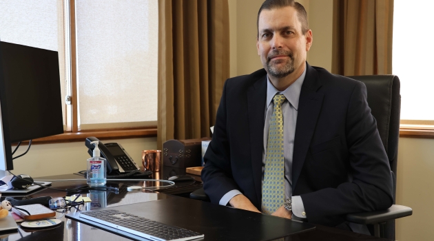 DEC President and CEO Rob Book poses for a photo at his desk.