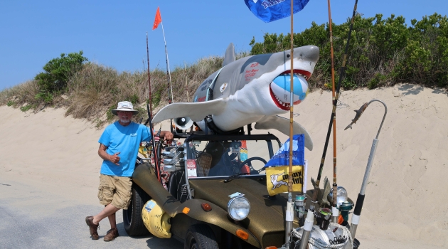DEC member Art Wilson poses with his dune buggy, decked out with fishing rods, reels and a 110-pound fiberglass shark he has named Bruce on top.
