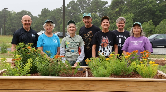 Co-op member Gary Liska (center) and Julie Callahan (right-of-center) pose with volunteers at the butterfly refueling station in Cape Henlopen State Park.