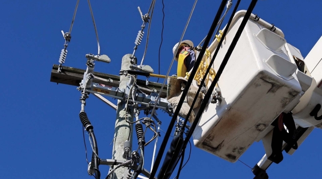 A DEC lineworker uses a bucket truck to access power lines.