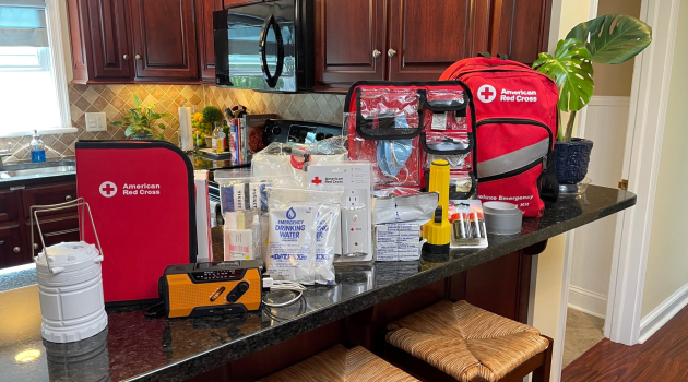 Photo displaying the items typically included in an emergency preparedness kit, such as a flashlight, radio, water and more.